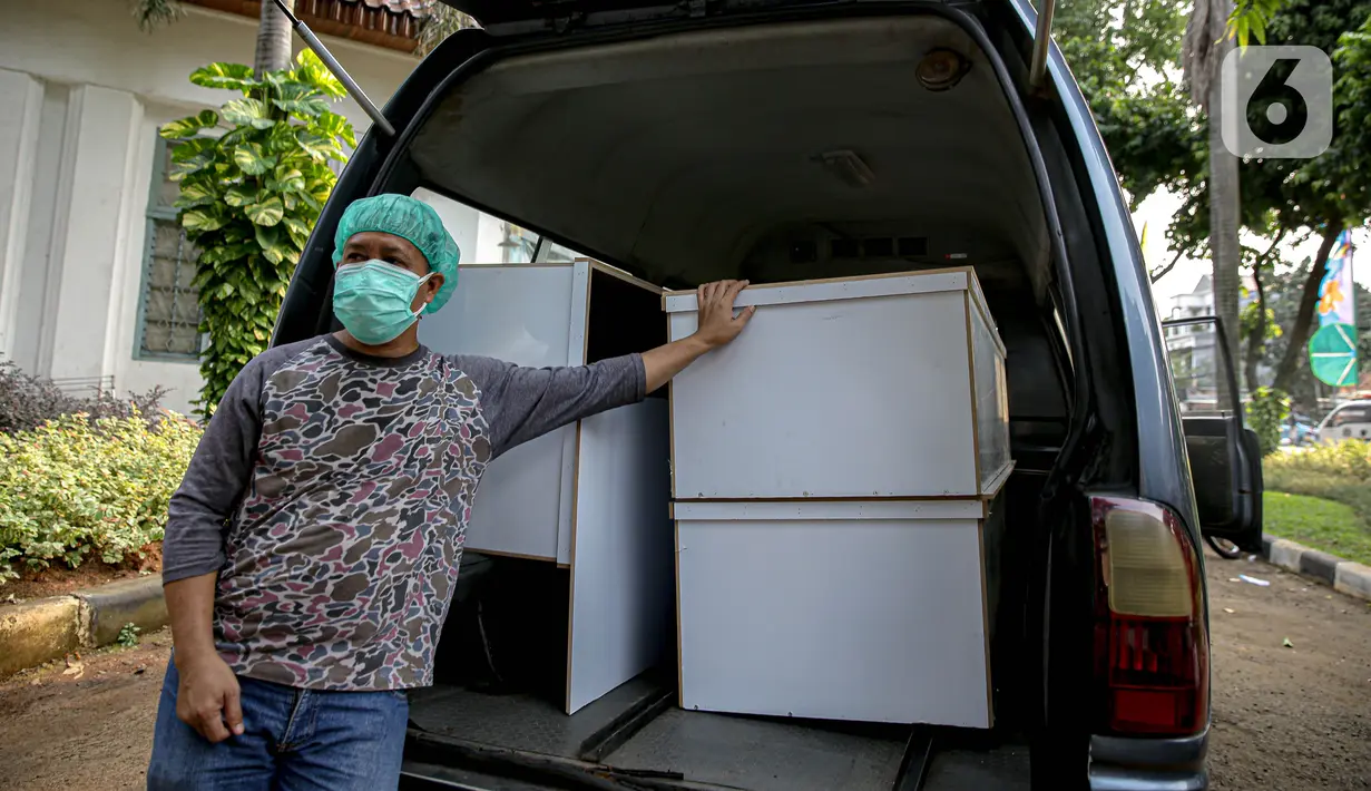 Petugas siap untuk didistribusikan peti jenazah COVID-19 ke rumah sakit di TPU Petamburan, Jakarta, Selasa (6/7/2021). Pemprov DKI Jakarta melalui Dinas Pertamanan dan Hutan menyediakan peti jenazah gratis untuk rumah sakit dan pasien COVID-19 di seluruh DKI. (Liputan6.com/Faizal Fanani)