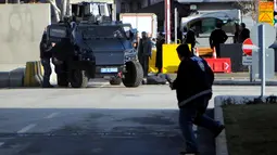 Kendaraan taktis mendekati seorang pria yang tergeletak di tanah, di luar kantor polisi di Gaziantep, Turki, Selasa (10/1). Seorang perwira polisi terluka ringan akibat penyerangan yang dilakukan pria tersebut bersama rekannya yang kabur. (AFP PHOTO/STR)