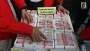 Petugas menunjukkan barang bukti saat rilis kasus pemalsuan dokumen dan uang palsu di Jakarta, Rabu (20/12). Bareskrim Polri mengamankan barang bukti berupa 22 unit kendaraan serta beberapa ikat uang palsu yang belum dipotong. (Liputan6.com/Angga Yuniar)