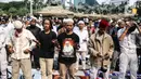 Massa aksi melaksanakan salat Ashar di sela unjuk rasa di Kawasan Patung Kuda, Jakarta, Selasa (13/10/2020). Massa aksi menolak Undang-Undang Cipta Kerja Omnibus Law tersebut salat beralaskan spanduk, kardus, hingga sajadah. (Liputan6.com/Faizal Fanani)