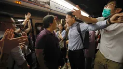 Penumpang berdebat dengan pengunjuk rasa yang mengganggu jalur kereta bawah tanah di Hong Kong (30/7/2019). Pengunjuk rasa telah mengganggu layanan kereta bawah tanah pada pagi hari perjalanan dengan menghalangi pintu-pintu masuk kereta dan mencegah mereka meninggalkan stasiun. (AP Photo/Vincent Yu)