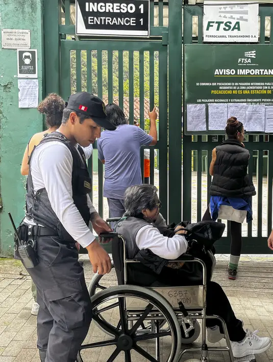 Turis menunggu di luar stasiun kereta Machu Picchu setelah layanan kereta api dihentikan karena kerusakan yang diduga disebabkan oleh pengunjuk rasa di Machu Picchu, Peru, Sabtu (21/1/2023). Turis terjebak di Machu Picchu, setelah demonstrasi mengganggu layanan transportasi dan merusak rel kereta terdekat. (Photo by Carolina Paucar / AFP)