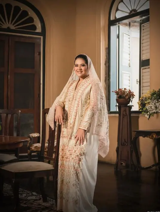 <p>Pada pemotretan kedua, Kahiyang tampil anggun mengenakan abaya dan kerudung nuansa emas. (Instagram/riomotret).</p>