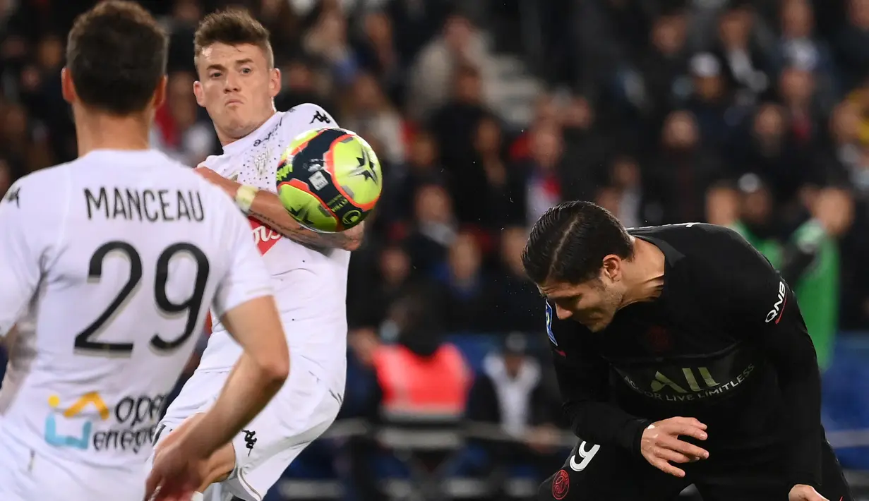 Penyerang Paris Saint-Germain (PSG) Mauro Icardi (kanan) menyundul bola saat pekan ke-10 Ligue 1 Prancis 2021/2022 kontra Angers di Parc des Princes, Sabtu (16/10/2021) dini hari WIB. PSG memastikan kemenangan 2-1 lewat gol penalti Kylian Mbappe. (FRANCK FIFE / AFP)