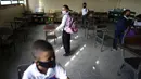 Para siswa menuju meja mereka pada hari pertama kembali ke kelas tatap muka sejak dimulainya pembatasan pandemi COVID-19 di sekolah umum di Caracas, Venezuela, 25 Oktober 2021. (AP Photo/Ariana Cubillos)