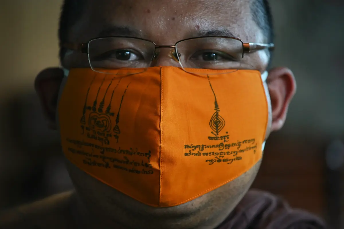 Biksu Budddha Chamnanwej Sutthiyano mengenakan masker terbuat dari botol plastik daur ulang dan ditulisi mantra spiritual, (Lillian Suwanrumpha/AFP)