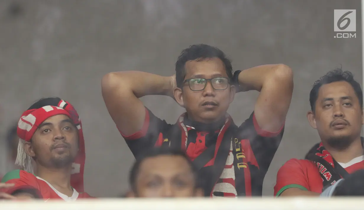 Ekspresi kesedihan suporter saat menyaksikan laga Timnas Indonesia U-19 melawan Jepang U-19 pada perempat final Piala AFC U-19 2018 di Stadion GBK, Jakarta, Minggu (28/10). Indonesia kalah 0-2. (Liputan6.com/Helmi Fithriansyah)