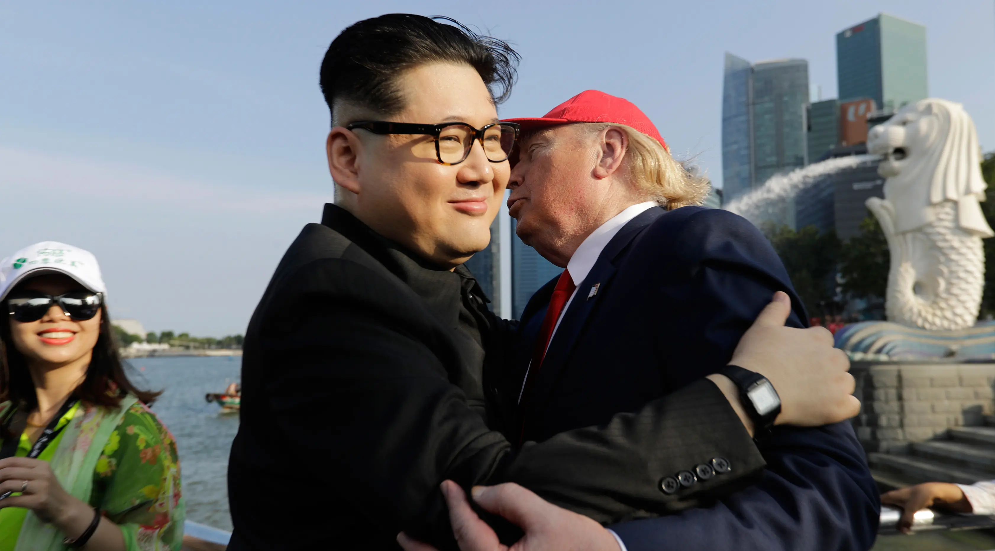 Kim Jong-un KW bernama Howard X dan Donald Trump KW, Dennis Alan berpelukan saat bertemu di Merlion Park, Singapura (8/6). Duo peniru itu melakukan aksi publisitas menjelang KTT Korea Utara - Amerika Serikat. (AP/Wong Maye-E)