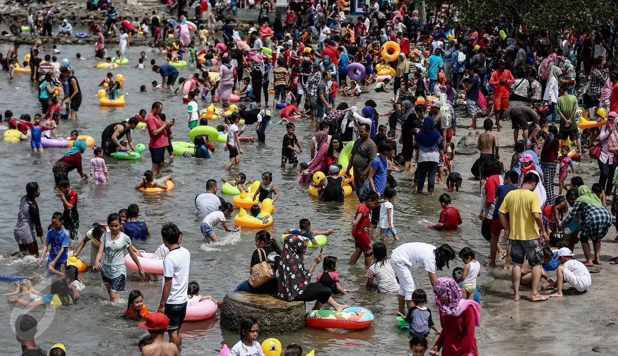 Sejumlah pengunjung Ancol sejak pagi hingga sore terpantau membludak, Jakarta, Minggu (25/12). Pantai Lagoon Ancol, Pantai Karnaval, dan sejumlah pantai di Ancol, kini semakin diramaikan akan kedatangan warga.  (Liputan6.com/Faizal Fanani)