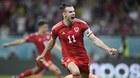 Berstatus tim debutan di Piala Dunia 2022, Wales sukses meraup satu poin dan terhindar dari kekalahan dalam laga menghadapi Amerika Serikat pada matchday pertama Grup B, Selasa (22/11/2022) dini hari WIB. Bertanding di Ahmad Bin Ali Stadium, Doha, Qatar, Gareth Bale dkk berbagi skor 1-1 dengan Tim Paman Sam. Tertinggal lebih dahulu lewat gol Timothy Weah pada babak pertama, Wales baru berhasil menyamakan skor pada menit ke-82 via eksekusi penalti Gareth Bale. (AP/Ashley Landis)