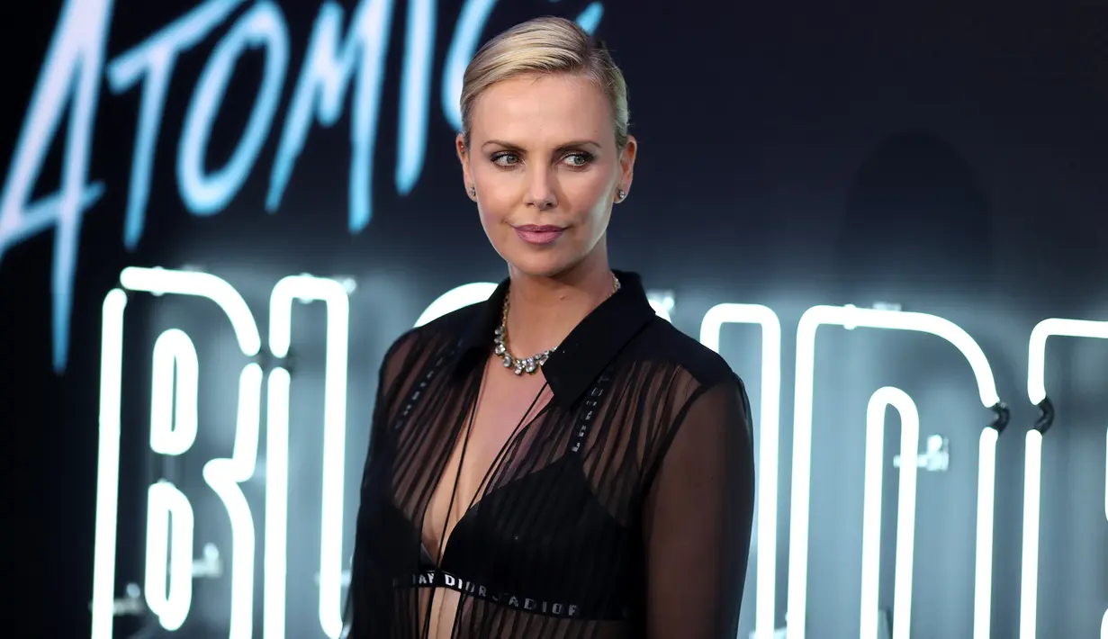 Aktris Charlize Theron berpose saat menghadiri pemutaran film terbarunya "Atomic Blonde" Fitur Fokus di Los Angeles, California (24/7). Charlize Theron tampil seksi dengan busana transparan dengan aksesoris kalung perak. (AFP Photo/Neilson Barnard)