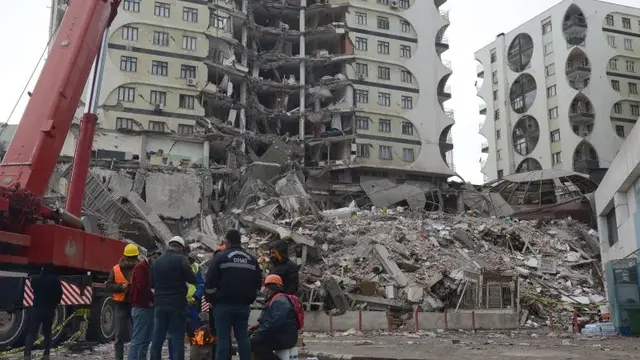 Petugas penyelamat dan sukarelawan mencari korban tewas dan hilang di reruntuhan bangunan yang runtuh di Diyarbakir, Turki, 6 Februari 2023, pasca dilanda gempa. (Ilyas Akengin/AFP)