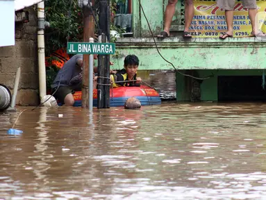 Warga menggunakan perahu karet berusaha keluar dari salah satu gang di Kawasan Rawajati yang tergenang banjir, Jakarta, Rabu Rabu (1/1/2020). Hujan yang mengguyur Jakarta sejak Selasa sore (31/12/2019) mengakibatkan banjir di sejumlah titik di Jakarta. (Liputan6.com/Helmi Fithriansyah)