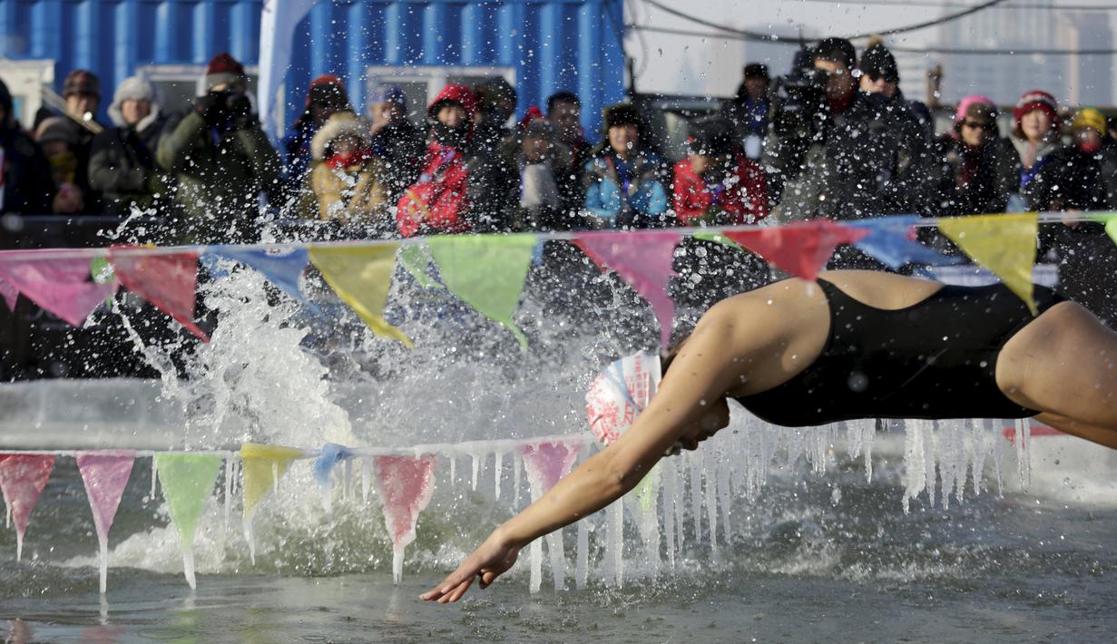 Peserta saat akan melompat ke kolam renang yang terbuat dari sungai Songhua yang membeku pada Kompetisi Renang Es Harbin di Provinsi Heilongjiang, Senin (5/1/2016). (REUTERS/Aly Song)