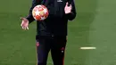 Pelatih Real Madrid Santiago Solari memegang bola saat memimpin latihan di kompleks latihan Valdebebas, Madrid, Spanyol, Senin (4/3). Solari meminta anak asuhnya tidak bersantai saat menghadapi Ajax Amsterdam. (AP Photo/Manu Fernandez)