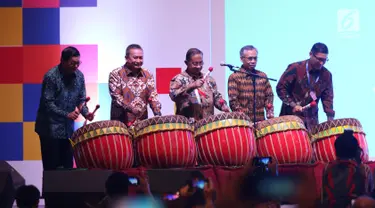 Menko Perekonomian Darmin Nasution (tengah) didampingi  Ketua OJK Wimboh Santoso (kedua kanan) dan Dirut BEI Inarno Djajadi (kiri) memukul gong saat membuka Capital Market Summit & Expo 2019 di Balai Sidang Jakarta Convention Center (JCC), Jakarta, Jumat (23/8/2019). (Liputan6.com/Angga Yuniar)