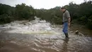 Seorang warga melintas dijalanan yang rusak akibat Tornado yang menyaou bagian kota Texas, Amerika Serikat, Jumat (30/10/2015). Tornando disertai hujan ini mengakibatkan Jalanan menjadi banjir dan sungai meluap. (REUTERS/Ilana Panich - Linsman)