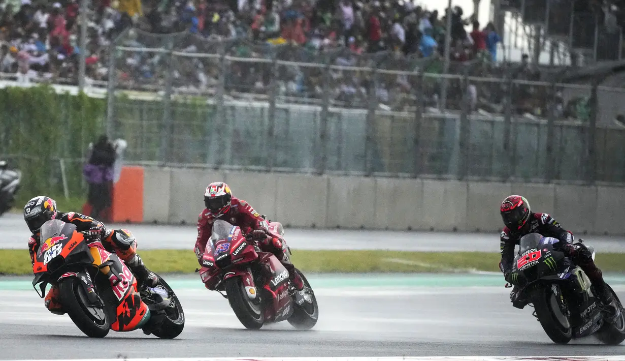 Memulai balapan dari posisi ke-7, Miguel Oliveira (kiri) langsung mengambil alih pimpinan dari Fabio Quartararo (kanan) yang menempati pole position di lap kedua. (AP/Achmad Ibrahim)