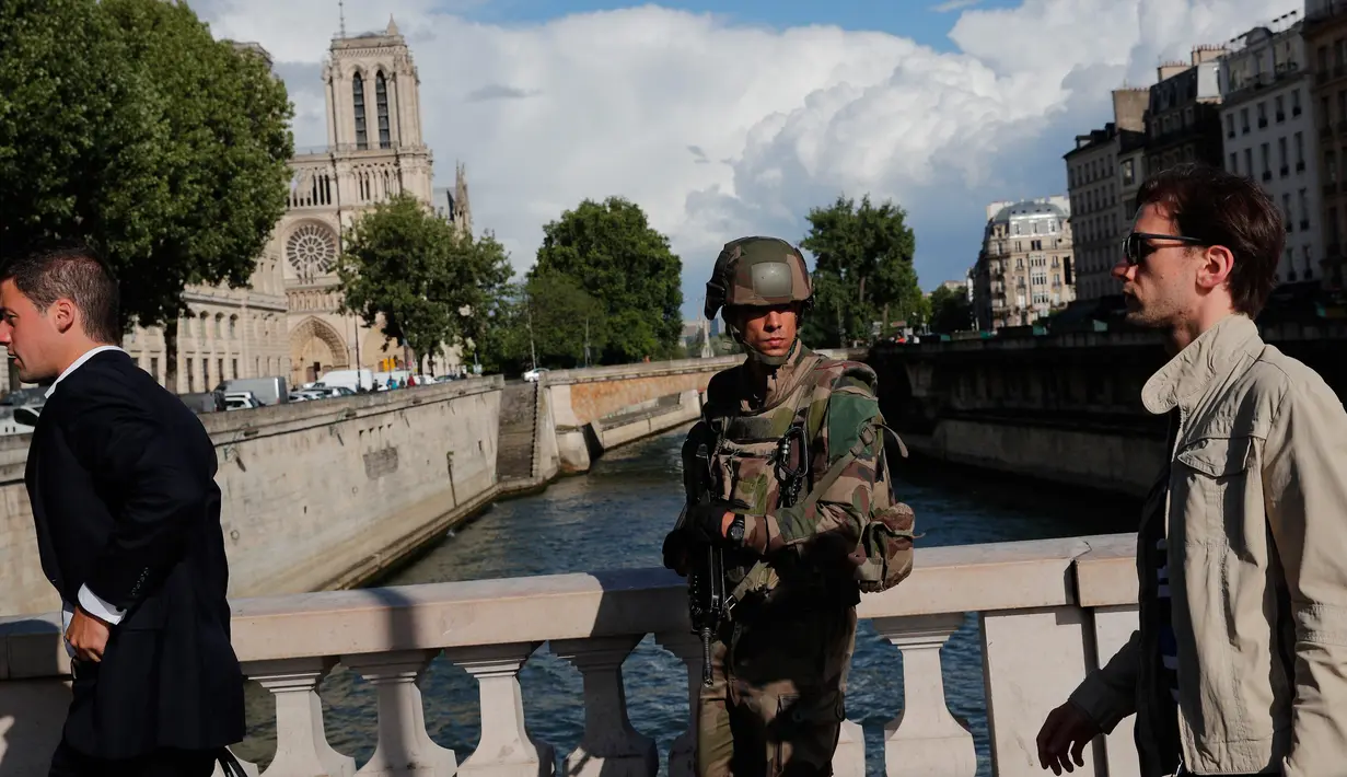 Seorang tentara melakukan patroli setelah aksi penyerangan oleh pria bersenjata palu di luar Katedral Notre-Dame, Paris, Selasa (6/6). Kawasan di sekitar katedral telah ditutup dan orang-orang diminta untuk tidak mendekat. (AP Photo/Christophe Ena)