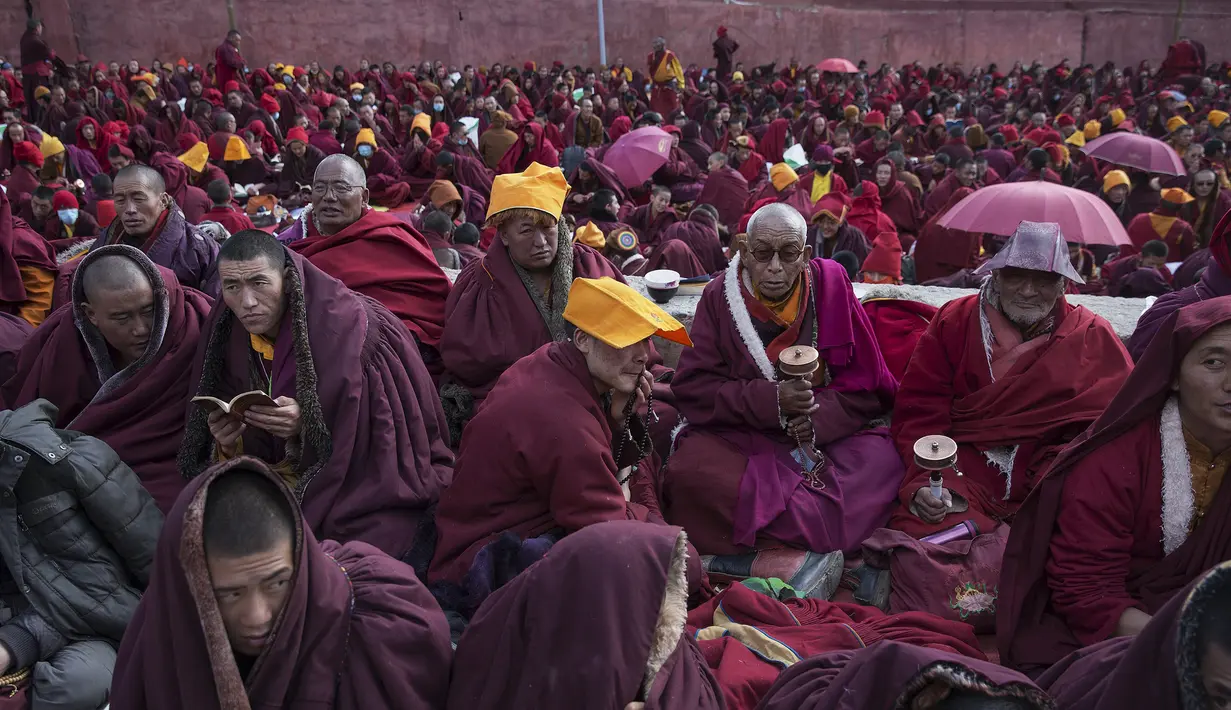 Para Biksu Tibet Menyelimuti dirinya dengan jubah dari cuaca yang dingin saat ikuti Utmost Bliss Dharma di Larung Wuming Buddha Institute, Tibet, Cina (1/11/2015). Tempat ini terletak pada 3700-4000 meter diatas laut. (REUTERS/Damir Sagolj)