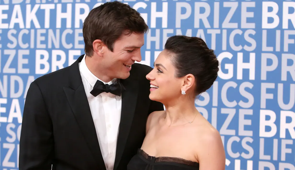 Pasangan selebriti, Ashton Kutcher dan Mila Kunis saling tatap saat berpose di karpet merah Breakthrough Prize Awards di California, 3 Desember 2017. Mila dan Ashton akhirnya kembali menampilkan kemesraan mereka di publik. (Jesse Grant/GETTY IMAGES/AFP)