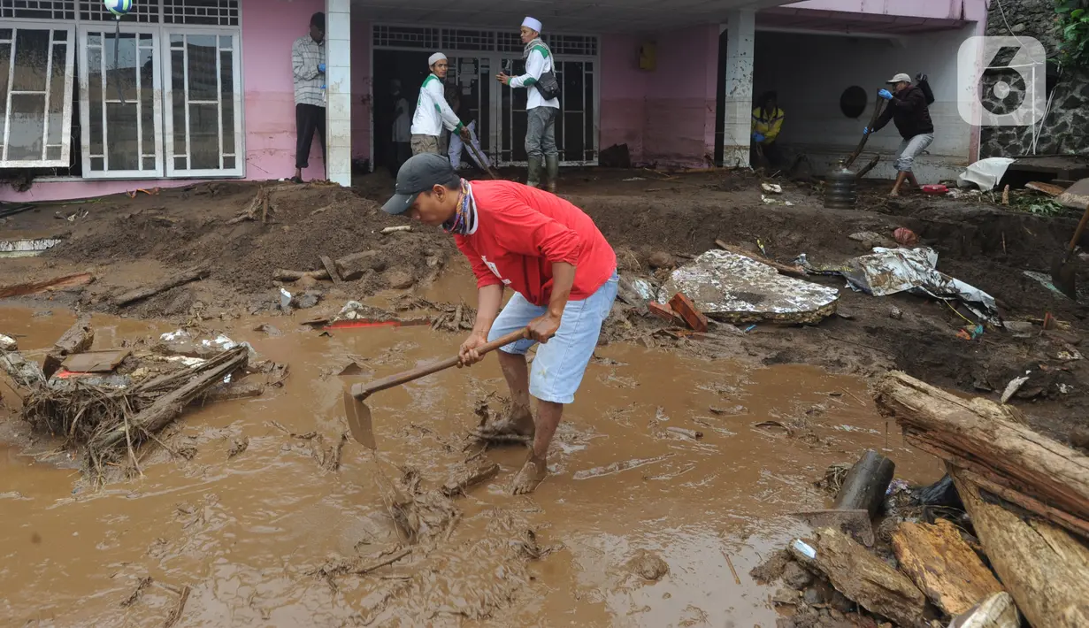 Warga membersihkan halaman rumah usai banjir bandang melanda Kampung Cibuntu, Desa Pasawahan, Kecamatan Cicurug, Sukabumi, Jawa Barat, Selasa (22/9/2020). Data sementara puluhan bangunan rusak berat, 12 rumah hanyut, dan dua korban hilang masih dicari. (merdeka.com/Arie Basuki)