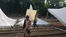 Pekerja mengangkat papan untuk menyelesaikan tenda relawan di Jalan Setiabudi, Medan, Senin (20/11). Menurut petugas bagian dekorasi, ada banyak tenda yang dipasang di 3 titik berbeda, seperti untuk tamu VIP, dan lokasi resepsi. (Liputan6.com/Aditya Eka)