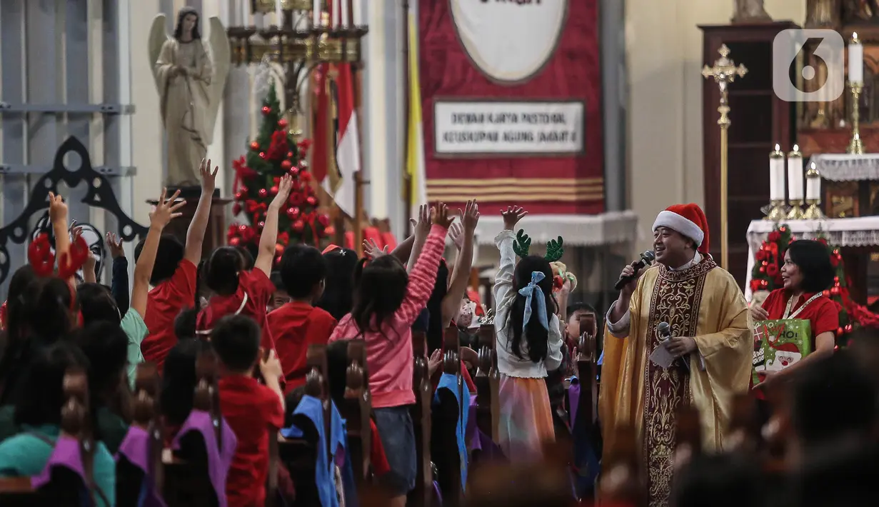 Pastor Kepala Paroki Romo Yohannes Deodatusi SJ menyapa anak-anak saat memimpin jalannya misa keluarga di Gereja Katedral, Jakarta, Rabu (25/12/2024). (Liputan6.com/Angga Yuniar)