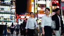 Foto pada 22 September 2018, orang-orang berjalan di distrik Shinjuku, Tokyo. Seiring dengan lampu jalanan dan pertokoan di Shinjuku yang kian meriah di malam hari, masyarakat lokal dan wisatawan pun mengalir tanpa henti. (AFP PHOTO / Martin BUREAU)