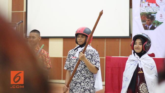 Setelah dinyatakan sah sebagai Bu Lurah, calon anggota Paskibraka 2019 ini dilantik dengan cara yang unik. Shelly disulap menjadi 'Superman' bersayapkan spanduk berisi tanda tangan seluruh penghuni Desa Bahagia (Liputan6.com/Sammy 'Azmy)