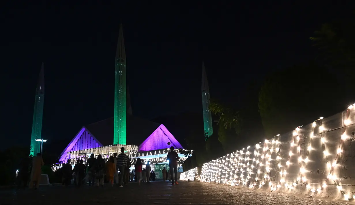Bangunan masjid Faisal yang diterangi selama perayaan hari kelahiran Nabi Muhammad SAW atau biasa disebut Maulid Nabi di Islamabad, Pakistan, Senin (18/10/2021). Peringatan Maulid Muhammad tak hanya diperingati umat Islam di Indonesia, tapi juga di berbagai negara. (Farooq NAEEM/AFP)