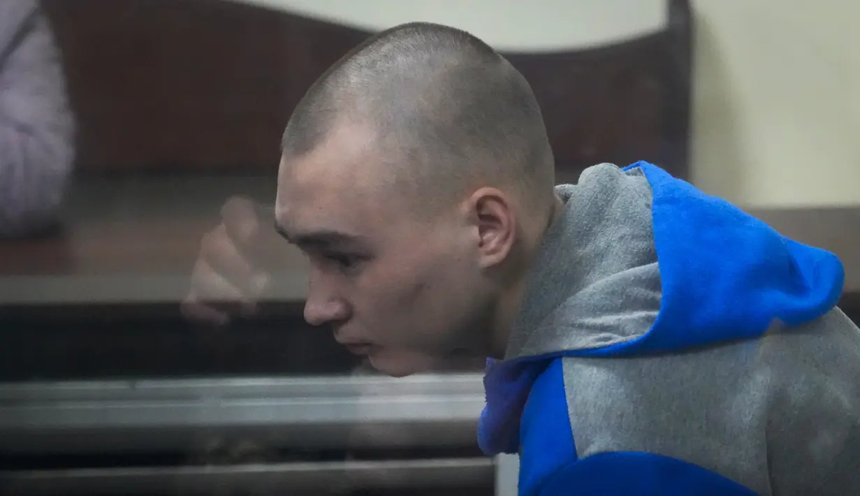 <p>Tentara Rusia, Sersan Vadim Shishimarin (21) terlihat di balik kaca selama sidang pengadilan di Kyiv, Ukraina, Rabu (18/5/2022). Sersan Vadim Shishimarin dapat terancam hukuman seumur hidup karena membunuh warga sipil Ukraina berusia 62 tahun di desa Chupakhivka, Ukraina timur laut pada 28 Februari. (AP Photo/Efrem Lukatsky)</p>