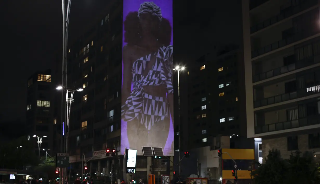 Gambar model di atas catwalk diproyeksikan pada sebuah gedung selama Sao Paulo Fashion Week di Sao Paulo, Brasil, Rabu (4/11/2020). Perancang busana meninggalkan catwalk dan mengandalkan teknologi digital untuk memamerkan karya koleksi spring/summer mereka. (AP Photo/Marcelo Chello)