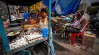 Seorang pedagang kaki lima menyiapkan makanan saat seorang pria makan di sebuah pasar grosir sayuran di Guwahati, India, Rabu (1/2/2023). Pemerintah Perdana Menteri India Narendra Modi meningkatkan belanja modal sebesar 33% untuk memacu pertumbuhan ekonomi dan menciptakan lapangan kerja menjelang pemilihan umum tahun depan. (AP Photo/Anupam Nath)