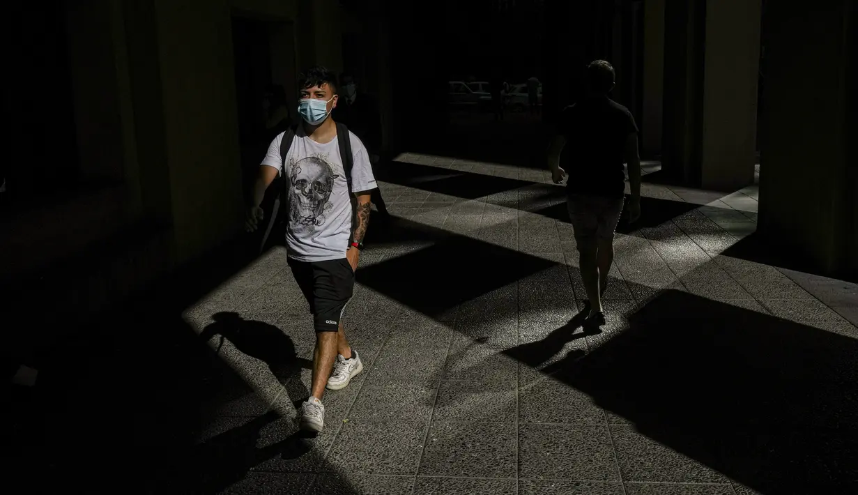 Seorang pejalan kaki memakai masker di pusat kota Santiago, Chili, Rabu (5/4/2022). Chile akan melonggarkan aturan protokol kesehatan Covid-19 pada 14 April dan berhenti mewajibkan penggunaan masker di ruang terbuka. (AP Photo/Esteban Felix)