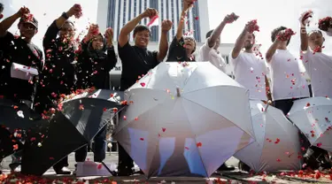 Sejumlah massa yang tergabung dalam Koalisi Masyarakat Sipil Penegak Citra DPD menaburkan bunga pada payung sebagai bentuk simbol kekhawatiran matinya keadilan dan penegakan hukum di depan Mahkamah Agung, Jakarta, Rabu (7/6). (Liputan6.com/Faizal Fanani)