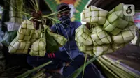 Pedagang menunjukkan kulit ketupat dagangannya di bawah kolong jembatan kawasan Pesanggrahan, Jakarta, Senin (10/5/2021). H-3 menjelang Hari Raya Idul Fitri 1442 H, penjualan kulit ketupat mulai marak yang dijual dengan harga Rp 8.000 per 10 buahnya. (Liputan6.com/Johan Tallo)