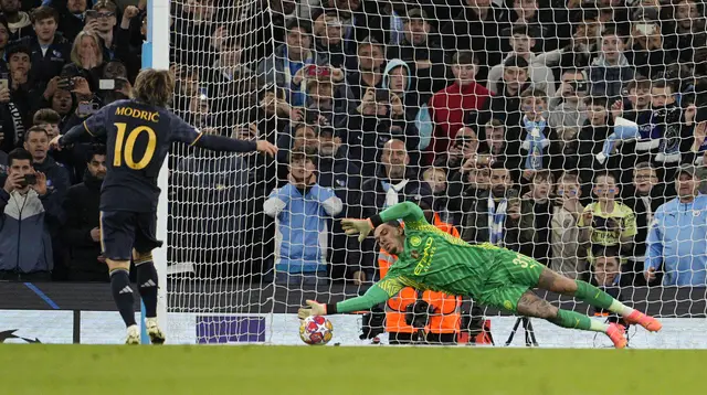 Penjaga gawang Manchester City Ederson, kanan, menyelamatkan penalti pemain Real Madrid Luka Modric saat adu penalti pada pertandingan sepak bola leg kedua perempat final Liga Champions antara Manchester City dan Real Madrid di Stadion Etihad di Manchester, Inggris, Rabu, 17 April 2024. ( Foto AP/Dave Shopland)