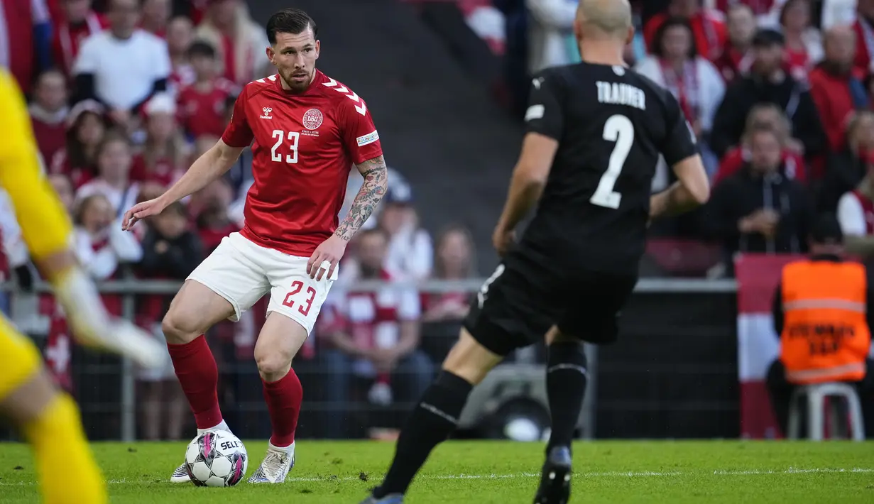 <p>Bek Denmark, Pierre Emile Hojbjerg membawa bola dari kawalan bek Austria, Gernot Trauner pada laga keempat Grup A1 UEFA Nations League 2022/2023 di Parken Stadium, di Kopenhagen, Selasa (14/6/2022). Denmark menang atas Austria dengan skor 2-0. (Claus Bech/Ritzau Scanpix via AP)</p>