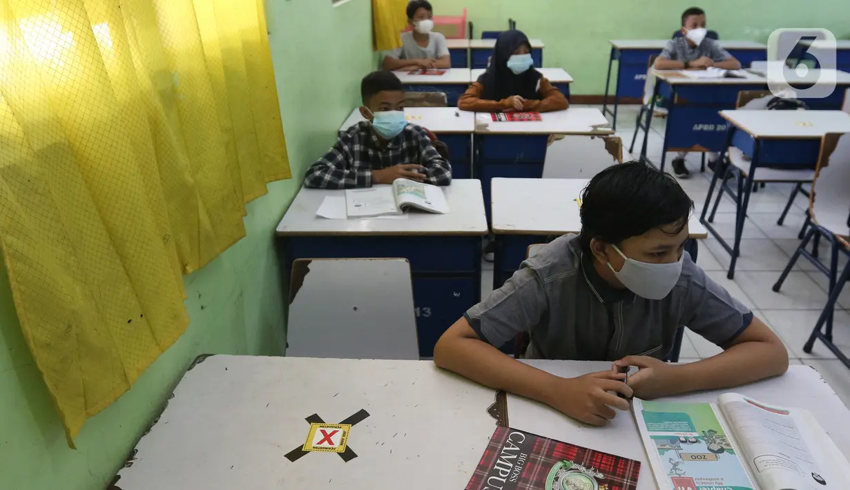 Sejumlah siswa mengikuti kegiatan belajar tatap muka di SMP Negeri 2 Bekasi, Selasa (23/3/2021). Di dalam kelas, mereka duduk di kursi yang sudah diatur jaraknya untuk meminimalkan risiko penularan virus corona COVID-19. (Liputan6.com/Herman Zakharia)