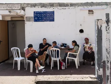 Warga makan siang di luar lingkungan tempat perlindungan bom atau shelter di Ashkelon, Israel, Selasa (31/10/2023). Warga Israel memanfaatkan tempat perlindungan darurat di rumah dan ruang publik ketika perang antara Israel dan kelompok militan Hamas meningkat. (AP Photo/Bernat Armangue)