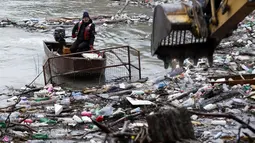Sebuah derek membersihkan sampah yang tersangkut di danau penimbunan Potpecko dekat Priboj, di barat daya Serbia, Kamis (12/1/2023). Serbia dan negara-negara Balkan lainnya kewalahan oleh sampah komunal setelah beberapa dekade diabaikan dan kurangnya kebijakan pengelolaan limbah yang efisien di negara-negara yang bercita-cita untuk bergabung dengan Uni Eropa. (AP Photo/Marjan Vucetic)