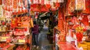 Seorang vendor menunggu pelanggan di kiosnya yang menjual dekorasi di Hong Kong (15/1/2021). Menjelang Tahun Baru Imlek, tahun ini menandai Tahun Sapi, yang jatuh pada 12 Februari. (AFP/Anthony Wallace)