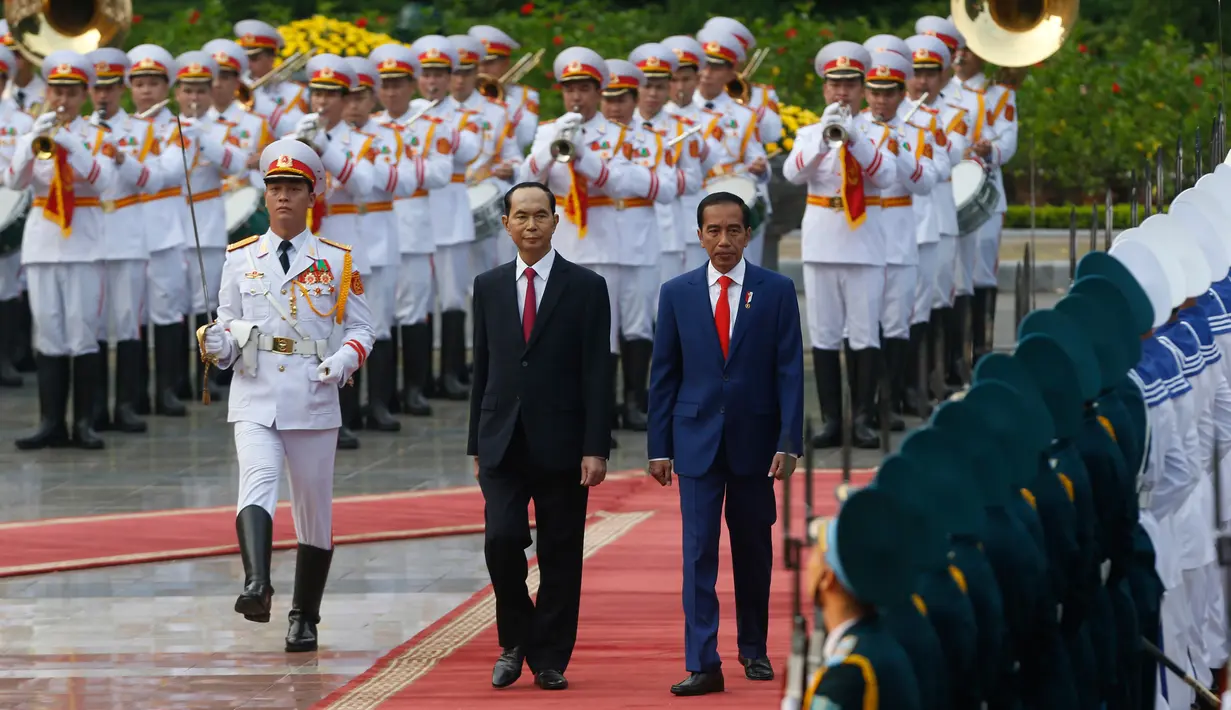 Presiden Joko Widodo dan Presiden Vietnam Tran Dai Quang berjalan saat upacara penyambutan di Istana Presiden, Hanoi, Vietnam (11/9). Usai lawatannya ke Korsel, Jokowi dan Ibu Negara Iriana beserta rombongan melanjutkan ke Vietnam. (Kham/AP Photo)