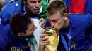 Daniele De Rossi (kanan) saat mencium trofi Piala DUnia 2006. De Rossi memulai karir di timnas Italia pada 2004 dan mencetak 13 gol hingga pensiun pada 2017. (AFP/Odd Andersen)