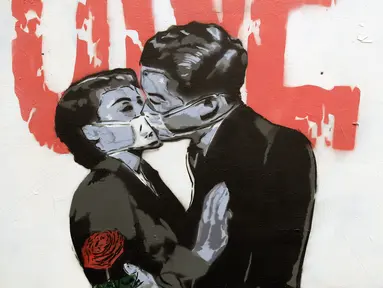 Mural karya Unify Artist menampilkan sepasang kekasih berciuman dengan mengenakan masker karena pandemi virus corona COVID-19 terlihat pada sebuah pagar di London, Inggris, Selasa (7/4/2020). (AP Photo/Matt Dunham)