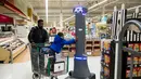 Seorang anak memegang robot bernama Marty yang sedang bekerja di pasar swalayan Giant Food Stores di Harrisburg, Pennsylvania, AS, Selasa (15/1). Robot Marty bertenaga baterai isi ulang dan memiliki beberapa kamera internal. (AP Photo/Matt Rourke)