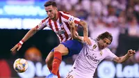 Gelandang Real Madrid, Luka Modric berebut bola dengan gelandang Atletico Madrid, Saul Niguez selama laga International Champions Cup 2019 di Arena Stadium Metlife, New Jersey (27/7/2019). Atletico menang telak 7-3 atas Real Madrid. (AFP Photo/Johannes Eisele)