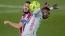 Penyerang Real Madrid, Vinicius Junior berebut bola dengan gelandang Atletico Madrid, Koke pada pertandingan La Liga Spanyol di stadion Alfredo Di Stefano, Spanyol, Minggu (13/12/2020). Madrid menang atas Atletico 2-0. (AP Photo/Bernat Armangue)