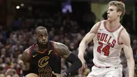 Bintang Cleveland Cavaliers, LeBron James (kiri) melewati penggawa Chicago Bulls Lauri Markkanen pada laga NBA 2017-2018 di Quicken Loans Arena, Kamis (21/12/2017) atau Jumat (22/12/2017) WIB. (AP Photo/Tony Dejak)